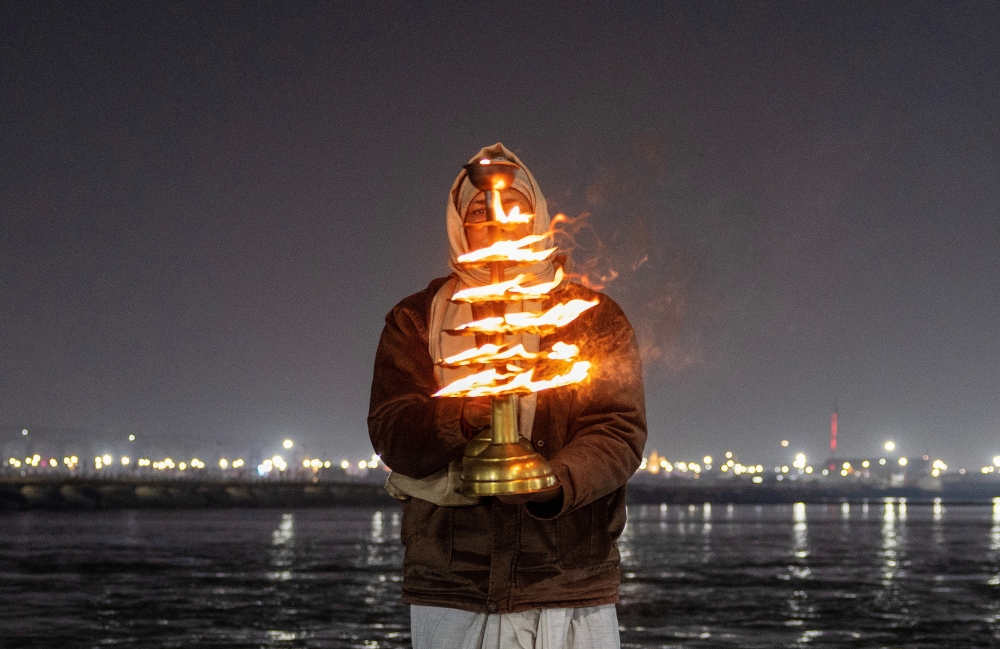 A Hindu devotee prays at the Sangam, the confluence of the Ganges and Yamuna rivers. — Reuters pic