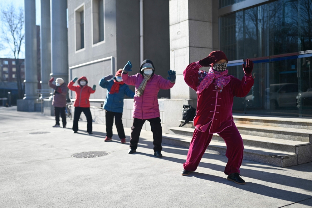 A group of women do Taichi along a road in Beijing on January 8, 2025. — AFP pic