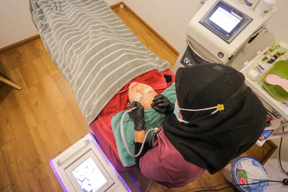 A beautician performs a facial treatment on a client in Ipoh, Perak. — File picture by Farhan Najib