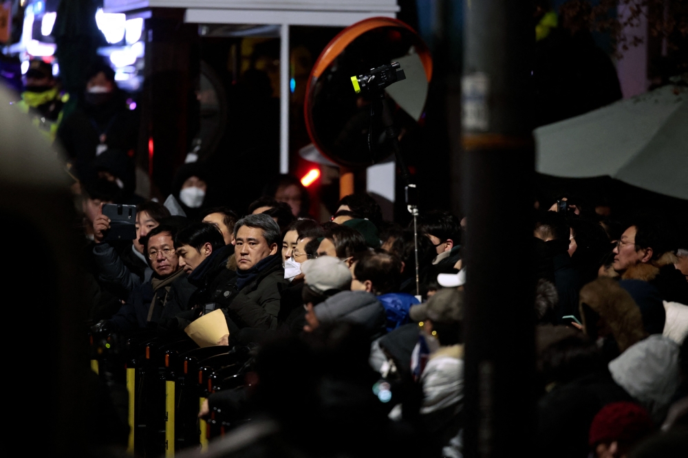 People gather inside the barricade blocking the road leading to the residence of impeached South Korean President Yoon Suk-yeol in Seoul January 15, 2025. — AFP pic