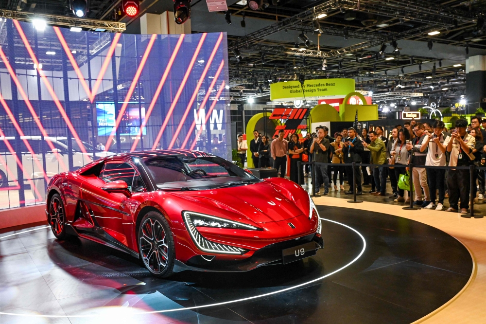 Visitors watch the BYD Yangwang U9 electric vehicle (EV) by Chinese car manufacturer BYD on display at Singapore Motorshow in Singapore on January 9, 2025. — AFP pic