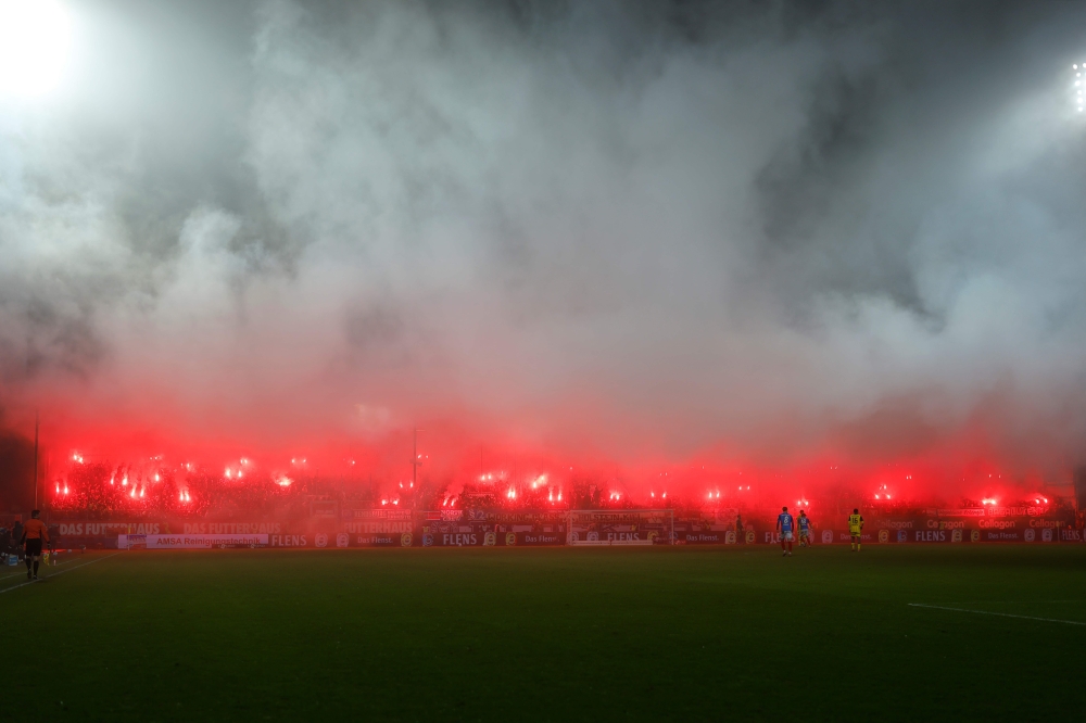Smoke raises from flares lit among the stand of Holstein Kiel’s supporters during the German first division Bundesliga match with Borussia Dortmund in Kiel January 14, 2025. — AFP pic