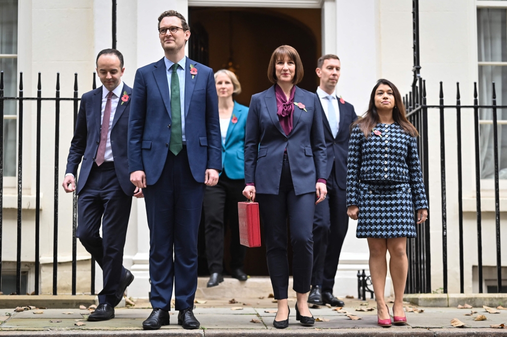 Britain’s Chancellor of the Exchequer Rachel Reeves (centre), holding the red Budget Box, poses with members of her Treasury team, including Economic Secretary Tulip Siddiq (right) outside of 11 Downing Street, in London, October 30, 2024. UK minister Tulip Siddiq announced her resignation from government on January 14, 2025 after becoming embroiled in a Bangladesh graft probe launched when her aunt, Sheikh Hasina, was ousted from power. — AFP pic