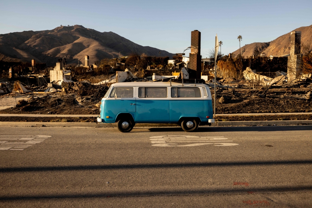 A blue Volkswagen van sits intact on a street amid homes destroyed by the Palisades Fire in Malibu, California, January 15, 2025. — AFP pic