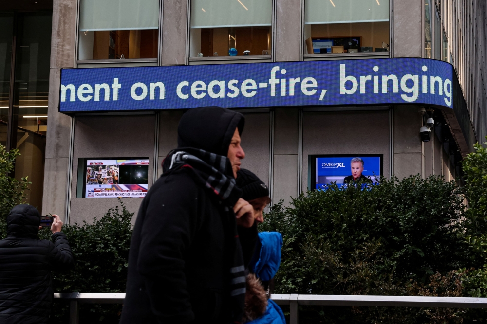 People pass by the Fox News ticker as it announces the Israel and Hamas ceasefire deal at the News Corp and WSJ headquarters in New York City January 15, 2025. Hamas political bureau member Khalil al-Hayya has commended Malaysia’s ‘honourable stance’ in supporting Palestine during the ongoing conflict, alongside other nations, Anadolu Agency (AA) reported. — Reuters pic  
