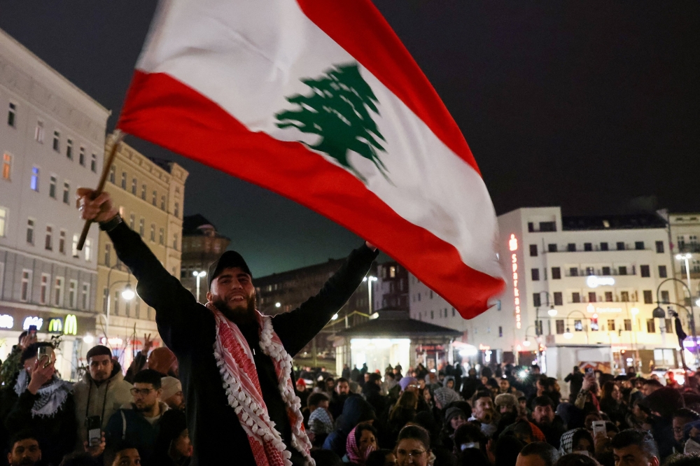 A demonstrator with a Lebanese flag celebrates news on a ceasefire between Hamas and Israel, in Berlin, Germany, January 15, 2025. — Reuters pic