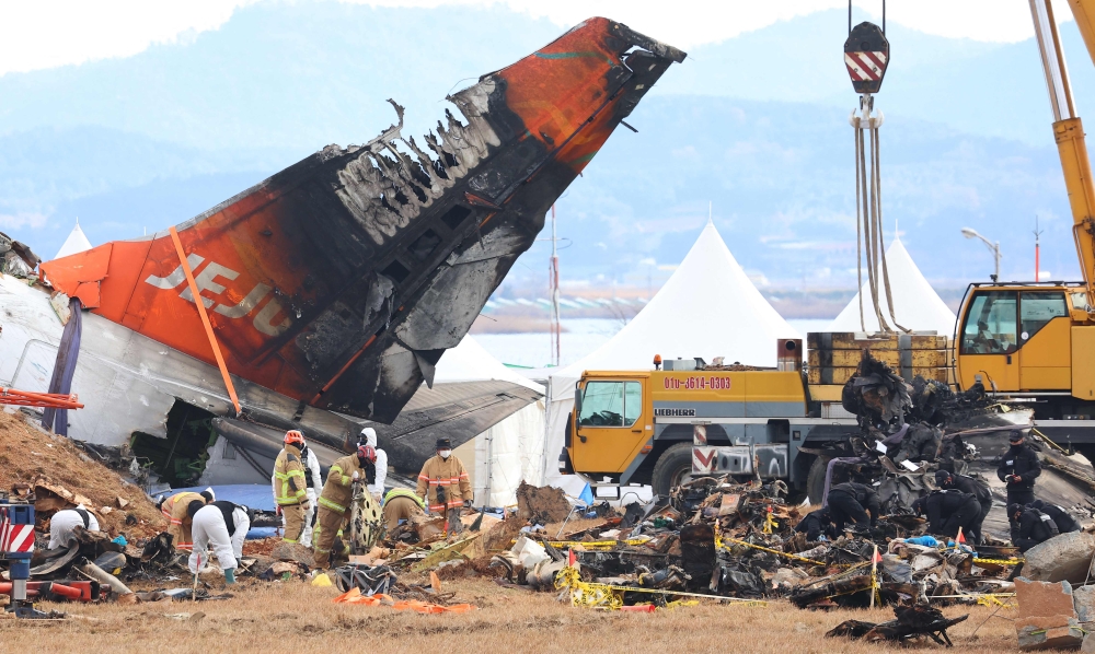 Investigators and emergency response personnel work at the site where a Jeju Air Boeing 737-800 aircraft crashed and burst into flames at Muan International Airport in Muan, some 288km southwest of Seoul on January 4, 2025. — Yonhap/AFP pic