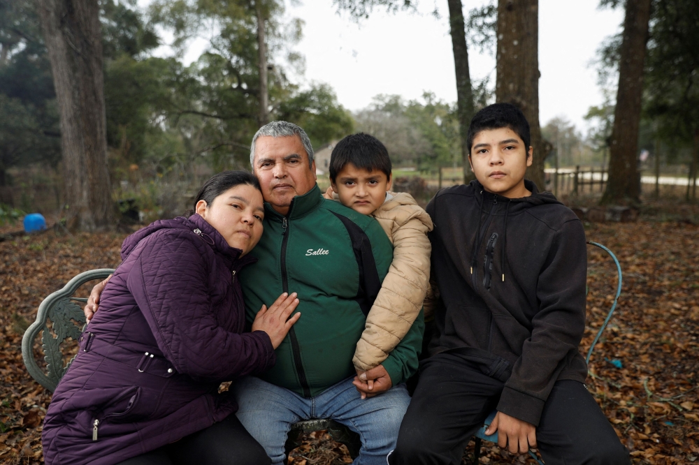 Blanca Figueroa from Guatemala, who has a deportation order dating back to when she first entered the country illegally and asked for asylum in 2016, poses at her home's yard with her family, Everson Figueroa, her husband Severiano Martinez, and youngest son Felipe Martinez, in Florida. — Reuters