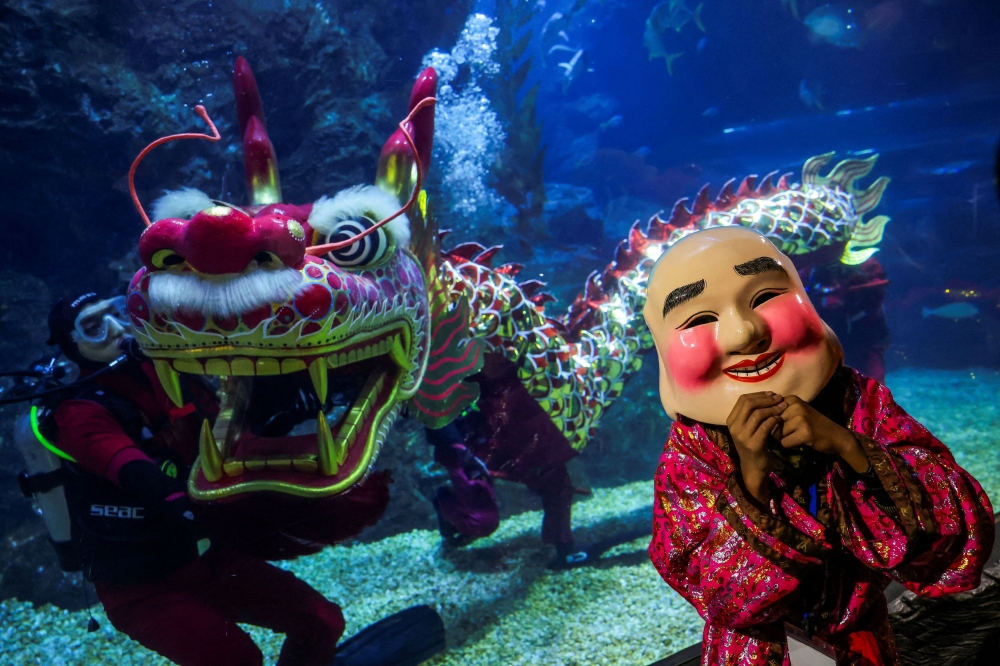 Divers perform a dragon dance ahead of the Lunar New Year celebrations at the Sea Life Bangkok Ocean World aquarium in Bangkok January 16, 2025. — Reuters pic