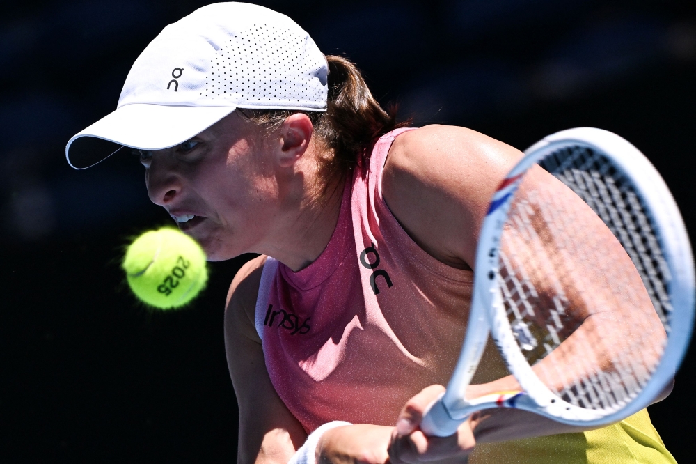 Poland’s Iga Swiatek hits a return against Britain’s Emma Raducanu during their women’s singles match on day seven of the Australian Open in Melbourne January 18, 2025. — AFP pic