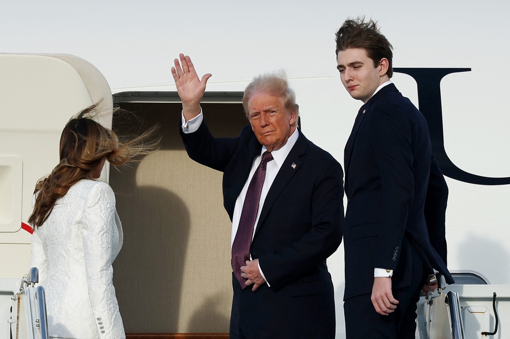 Donald Trump, Melania Trump and their son Barron board a US Air Force aircraft en route to Dulles, Virginia yesterday. — AFP pic
