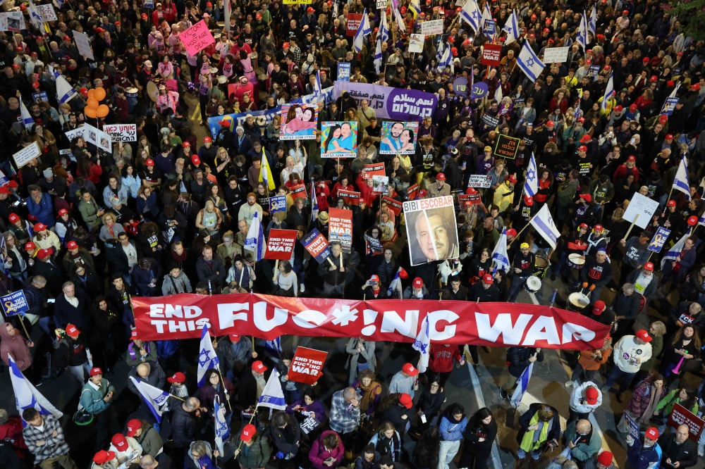 People hold placards and wave flags during an anti-government protest calling for action to secure the release of Israeli hostages. — Picture from AFP