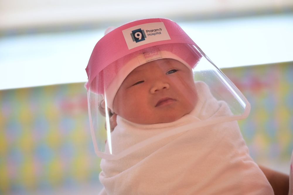 The Covid generation: A newborn at the Praram 9 Hospital in Bangkok, Thailand wears a face shield in an effort to halt the spread of the coronavirus on April 9, 2020. — AFP pic