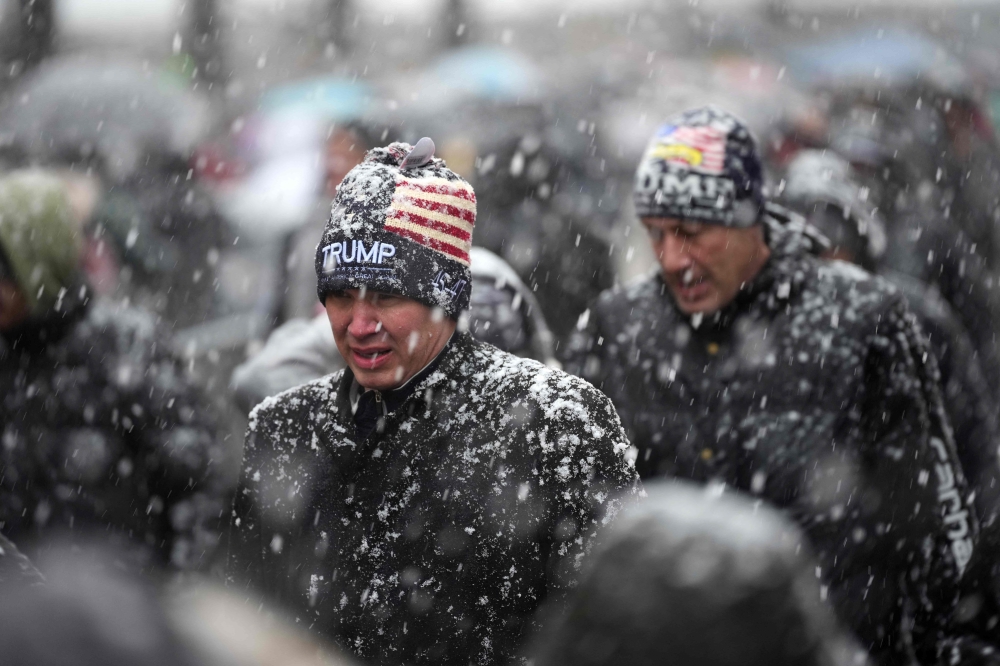 People queue in the snow at Capital One Arena for Donald Trump's victory rally. — Pic by AFP