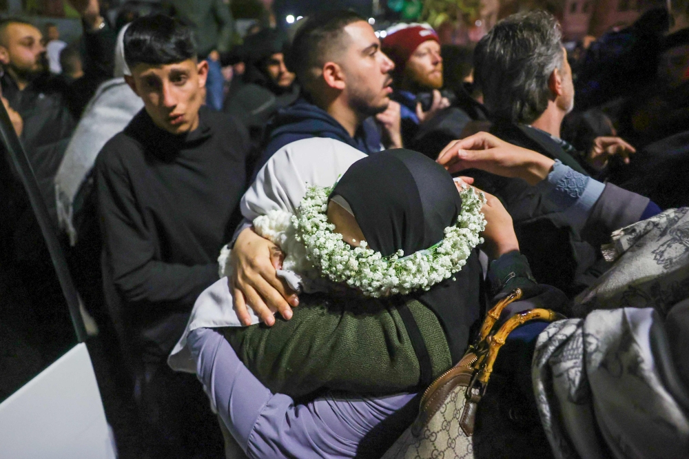 A Palestinian prisoner embraces a relative upon arrival after being set free. — Pic by AFP