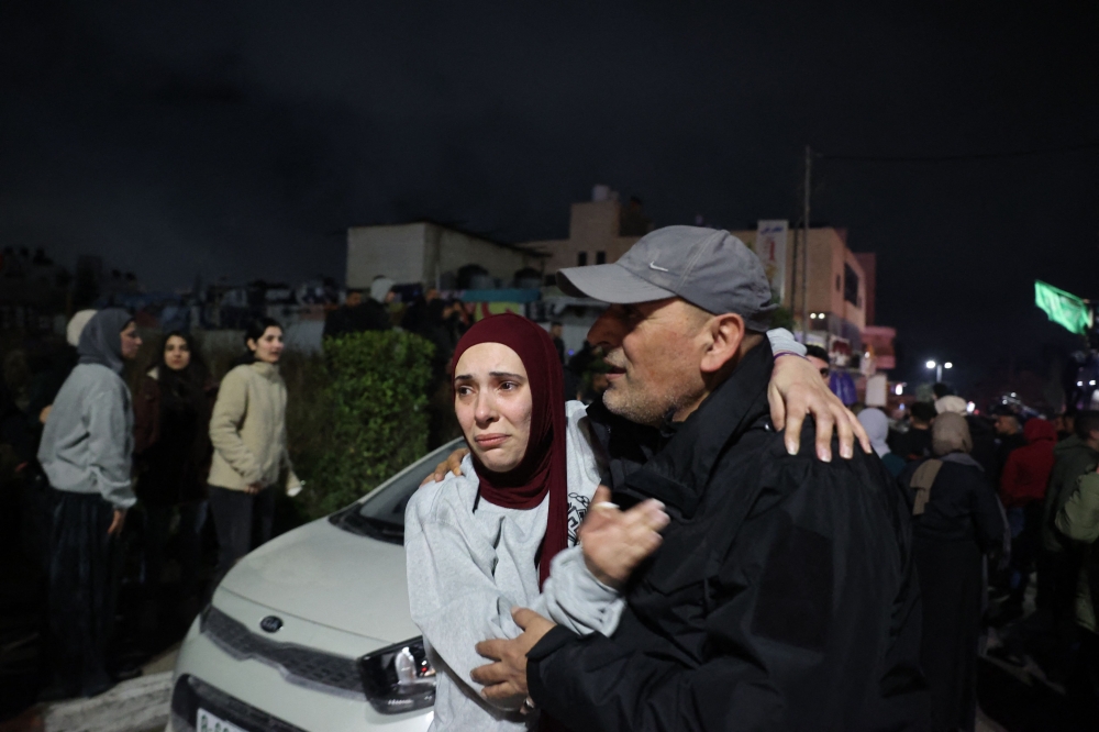 A Palestinian man embraces a loved one who was released from jail along with some 90 prisoners set free by Israel in the early hours of today. — Pic by AFP