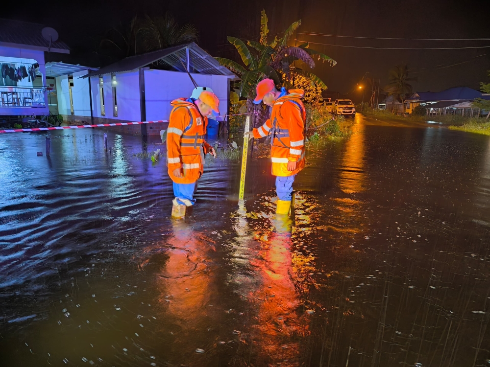 Mukah Civil Defence Force (APM) personnel monitor the flood situation around 3am this morning. — The Borneo Post