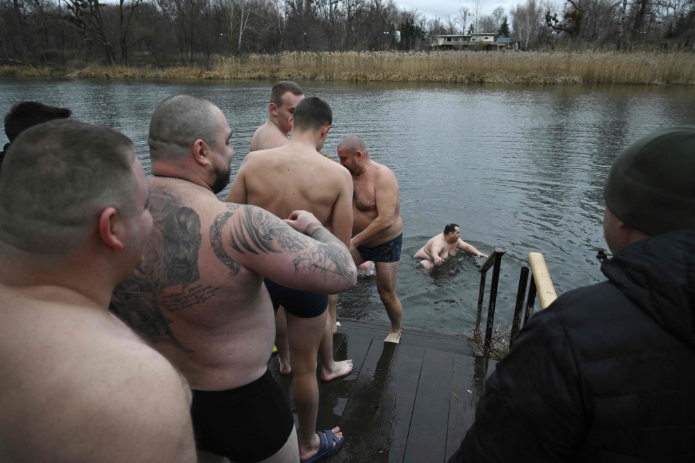 People bathe in the cold waters of the River Siverskyi Donets next to the Sviatogirsk Monastery during the Epiphany celebration in the town of Svyatogirsk, Donetsk region, on January 19, 2025. — AFP pic 
