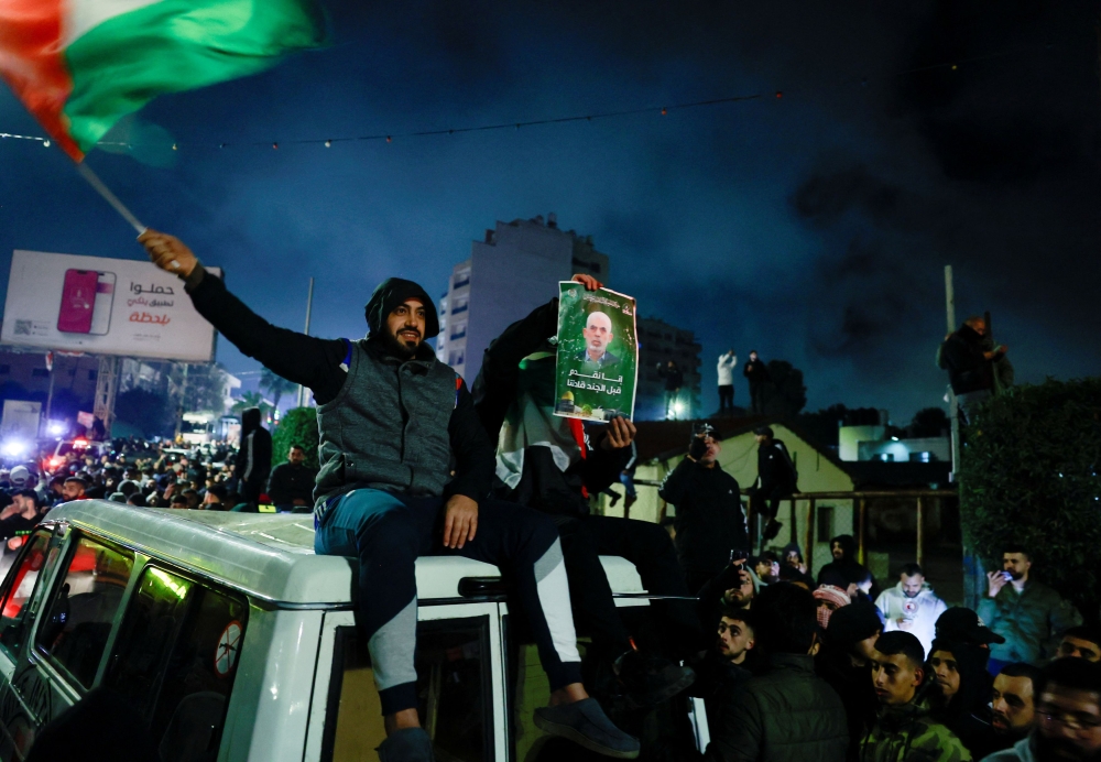 A person displays a poster with a picture of the late Hamas leader Yahya Sinwar after freed Palestinian prisoners are released from an Israeli jail as part of a hostages-prisoners swap and a ceasefire deal in Gaza between Hamas and Israel, in Ramallah, in the Israeli-occupied West Bank, January 20, 2025. — Reuters pic 