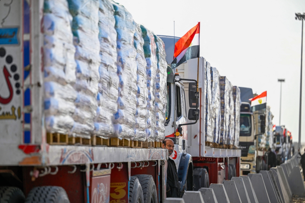 A driver waits next to trucks loaded with aid to cross into Gaza from the Egyptian side of the Rafah border crossing in Rafah on January 19, 2025. Trucks carrying humanitarian aid entered the Gaza Strip on January 19 after a long-awaited truce between Israel and Hamas came into effect, the United Nations said. — AFP pic 
