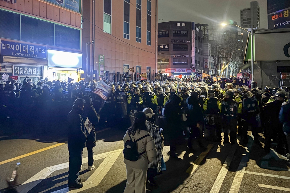 Police stand guard on a street near the Seoul Western District Court in Seoul yesterday after hundreds of pro-Yoon protesters smashed windows and broke down doors to enter the court following the extension of the detention of impeached South Korea President Yoon Suk Yeol.  Pic by AFP