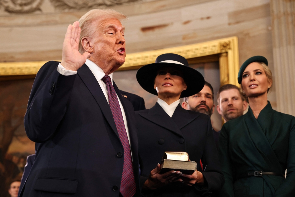 Donald Trump takes the oath of office as Melania Trump, Ivanka Trump, Donald Trump Jr. and Eric Trump look on during inauguration ceremonies in the Rotunda of the US Capitol in Washington, DC. — Pic by AFP