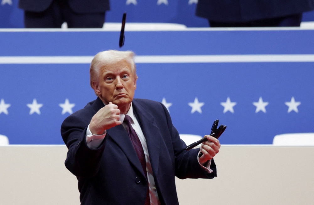 US President Donald Trump throws a pen during a rally on the inauguration day of his second presidential term, inside Capital One, in Washington January 20, 2025. — Reuters pic