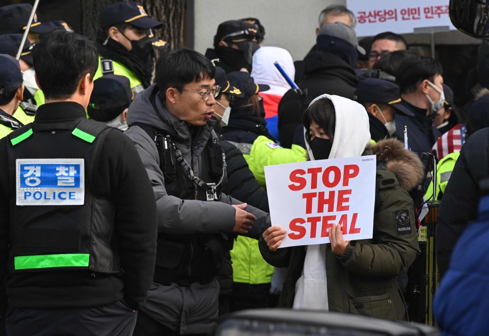 Police officers ask supporters of impeached South Korean President Yoon Suk Yeol to leave at the main gate of the Constitutional Court in Seoul. — Pic by AFP