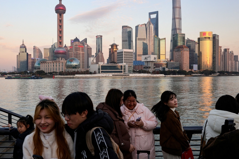 People hang out at The Bund as the financial district of Pudong is seen in the background in Shanghai, China, January 16, 2025. — Reuters pic 