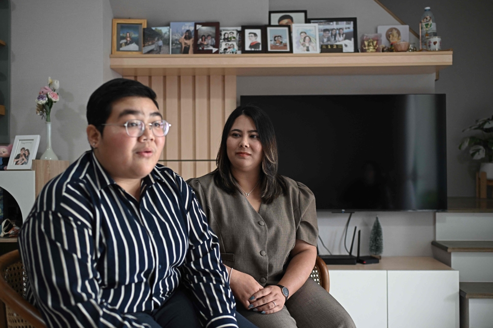 This photo taken on January 12, 2025 shows Niramon ‘New’ Kvunkaew (right) looking at Karisa ‘Fah’ Loywisut as they talk to AFP at their home in Bangkok. — AFP pic