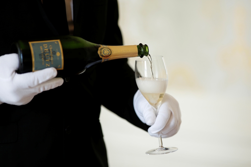 An employee serves a glass of Champagne during the traditional wine harvest at the Champagne house Deutz in Ay, France, September 22, 2016. — Reuters pic