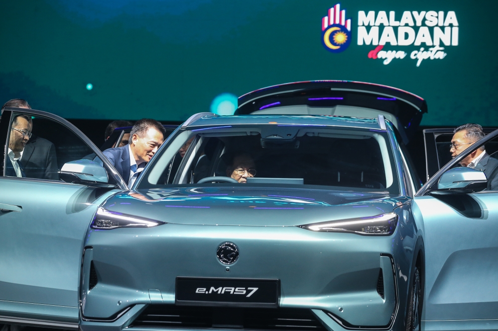 Prime Minister Datuk Seri Anwar Ibrahim takes a look inside the Proton e.MAS 7 during its official launch in Kuala Lumpur December 16, 2024. — Picture by Yusof Mat Isa