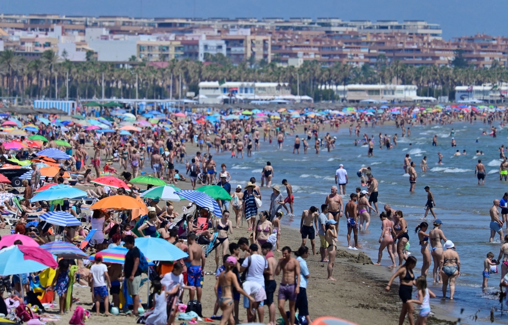 People crowd the beach in Valencia on July 5, 2024. A record 94 million foreign tourists craving for sun, sand and culture flocked to Spain in 2024 as the sector drives the country's bullish economy, the tourism minister said on January 15, 2025. — AFP pic