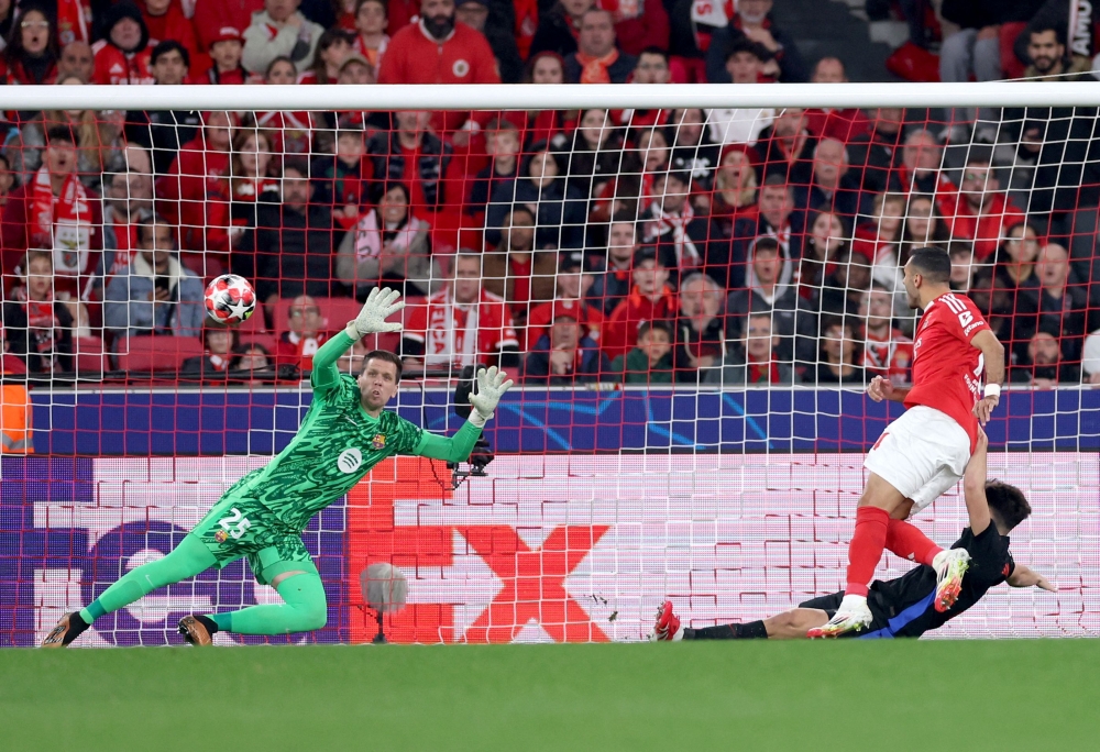 Benfica’s Vangelis Pavlidis scores his team’s first goal, beating Barcelona's goalkeeper Wojciech Szczesny. — Pic by AFP