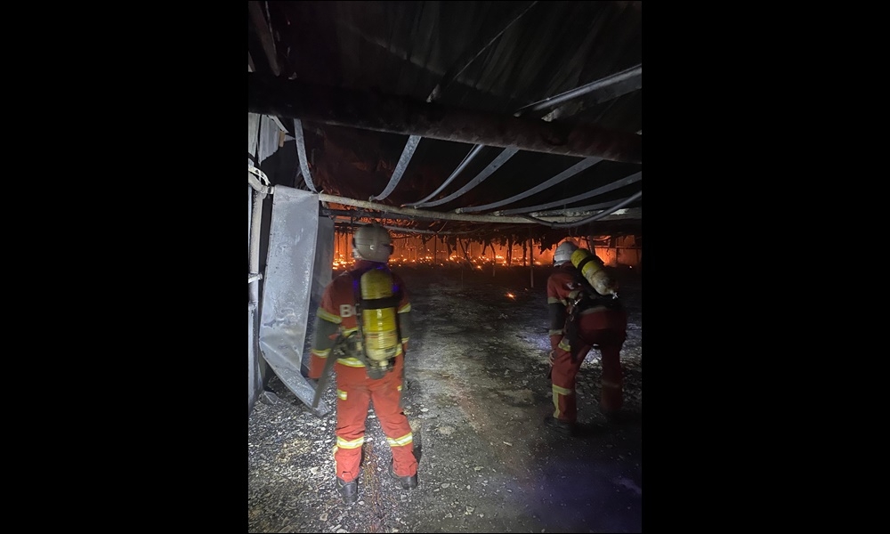 Handout photo shows firefighters in action during the fire that broke out at a poultry farm at Jalan Bakam. — The Borneo Post pic