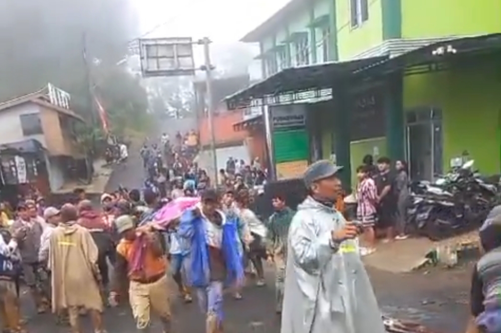 Volunteers carrying a body on a makeshift stretcher in Pekalongan. — Screenshot from X/roniabidin2