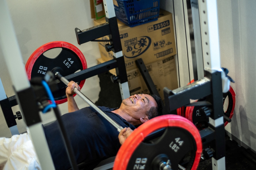 This picture taken on October 21, 2024 shows Ueko (nickname) a parolee recovering from drug addiction, doing weight lifting workout at a drug rehab centre in Sakai city of Osaka Prefecture. — AFP pic 