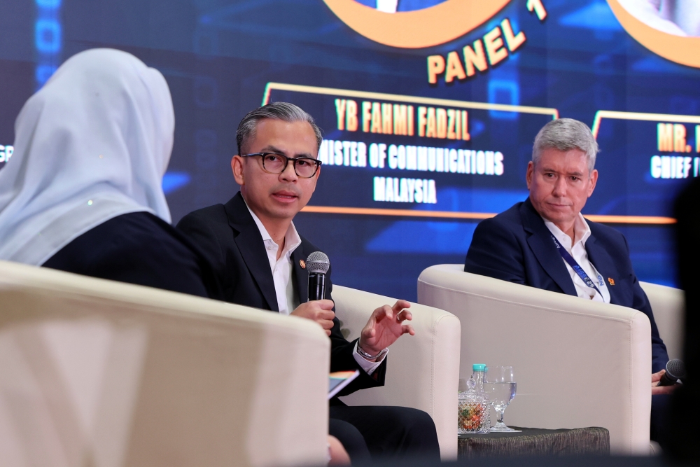 Communications Minister Fahmi Fadzil (centre) is one of the panellists at a forum session titled 