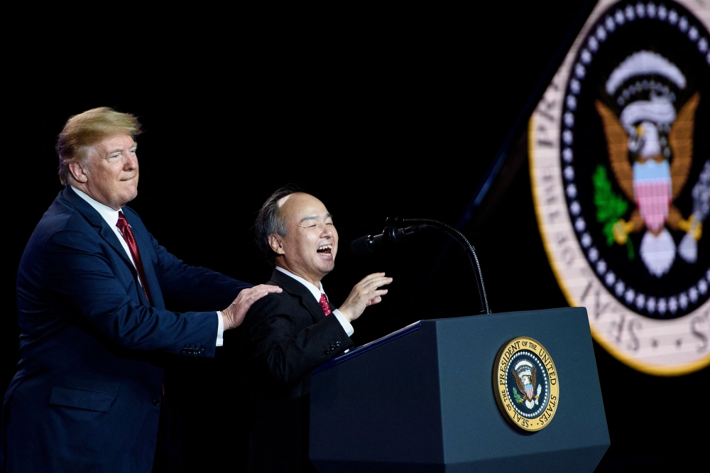US President Donald Trump listens while Masayoshi Son, chief executive officer of SoftBank, speaks at a Foxconn facility at the Wisconsin Valley Science and Technology Park in Mount Pleasant, Wisconsin in this file picture dated June 28, 2018. Son, the Japanese tycoon helming US President Trump’s big new AI push, is the son of an immigrant pig farmer with a spectacular but also sketchy investment record. — AFP pic 