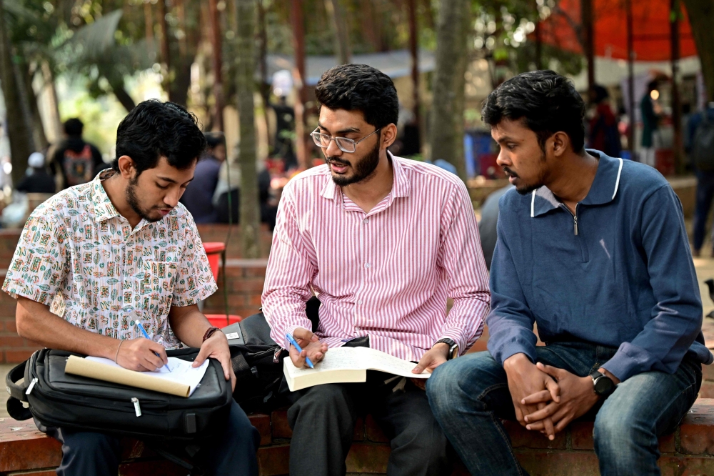 This photograph taken on January 14, 2025 shows Dhaka University student Mohammad Rizwan Chowdhury (centre), attempting a group exam at the university premises in Dhaka. — AFP pic