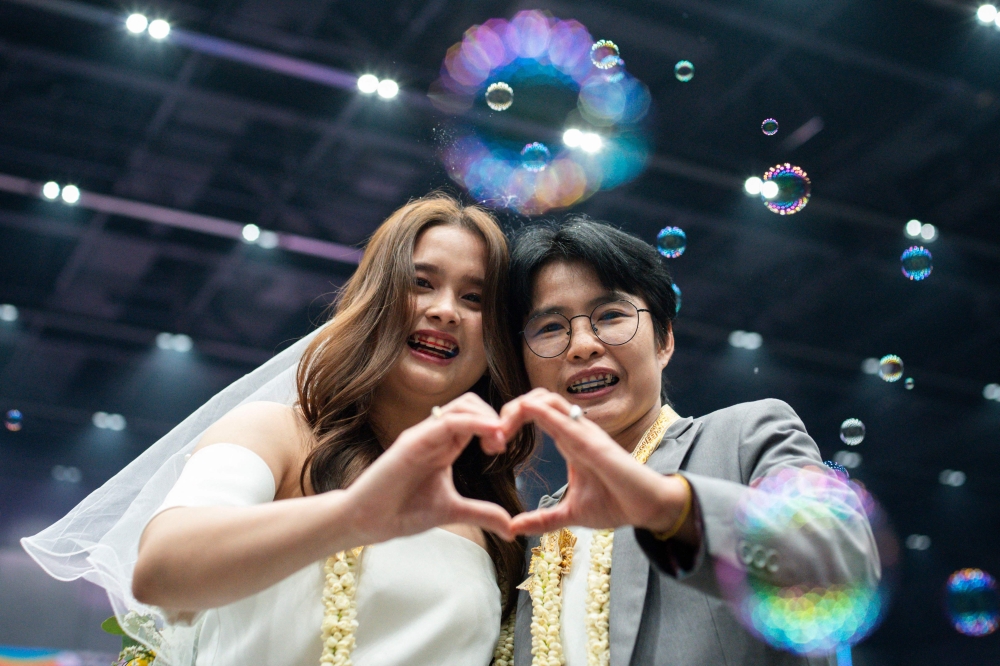Wasana liamyongyai (left) and Niramol pongkan (right), a same-sex couple, pose during their marriage registration event at Paragon shopping mall in Bangkok on January 23, 2025. — AFP pic