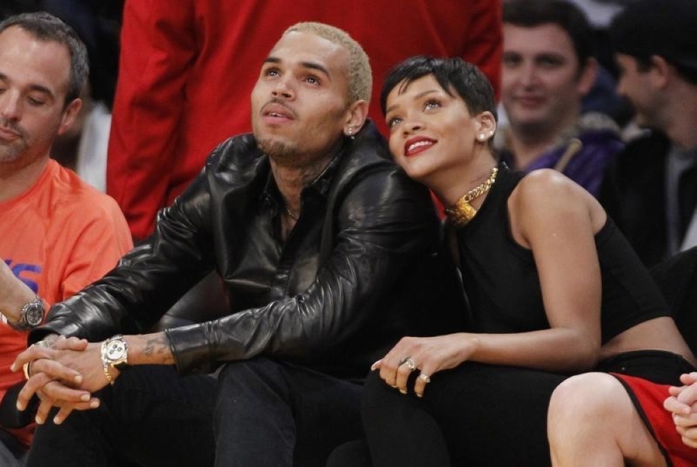 Recording artist Rihanna leans her head on Chris Brown as they sit together at the NBA basketball game between the New York Knicks and Los Angeles Lakers in Los Angeles in this file photo taken on December 25, 2012. — Reuters pic