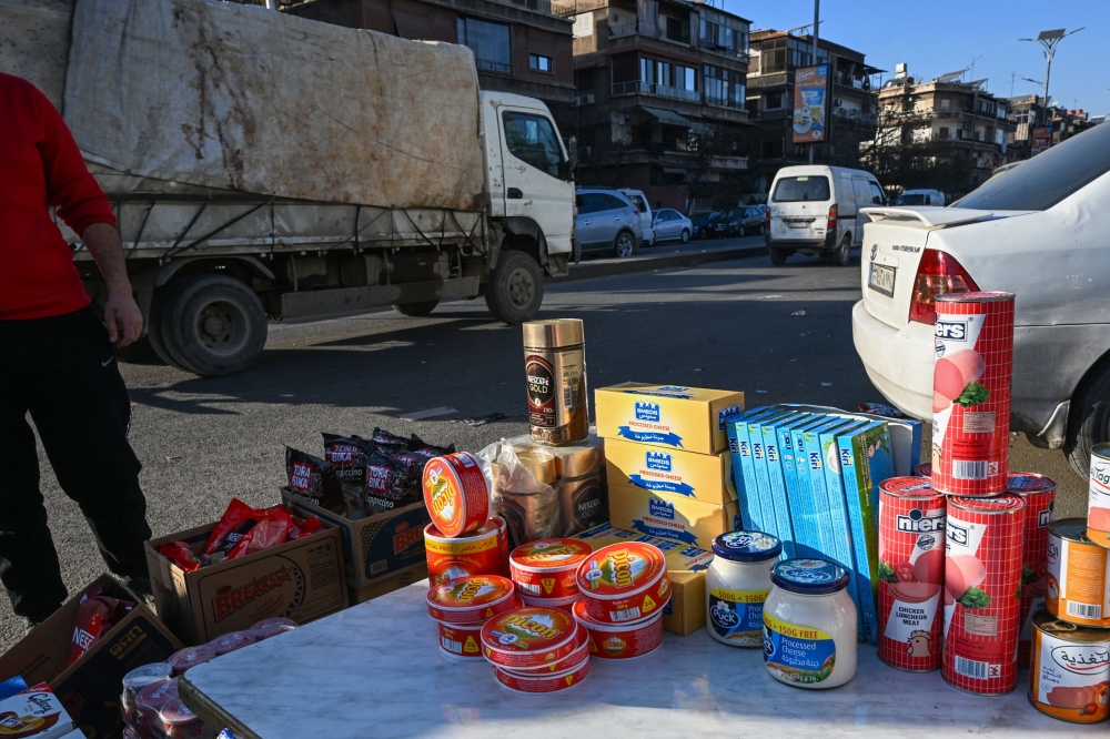 A street vendor offers imported food brands at his stall by a busy street in Damascus on January 14, 2025. — AFP pic 