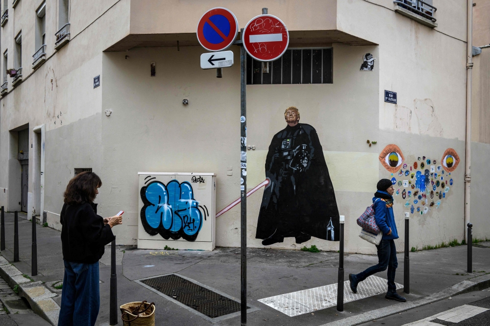 A pedestrian stands next to a graffiti created by French artist Big Ben street Art, depicting US Donald Trump as Darth Vader in Lyon, on November 6, 2024. — AFP pic 