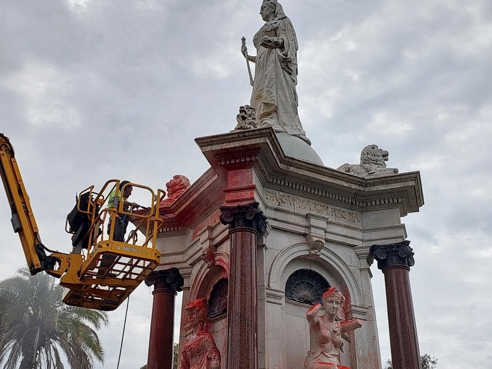 A council worker cleans the statue to Britain’s Queen Victoria that was defaced in the Royal Botanic Gardens Victoria in Melbourne in 2024. — AFP pic