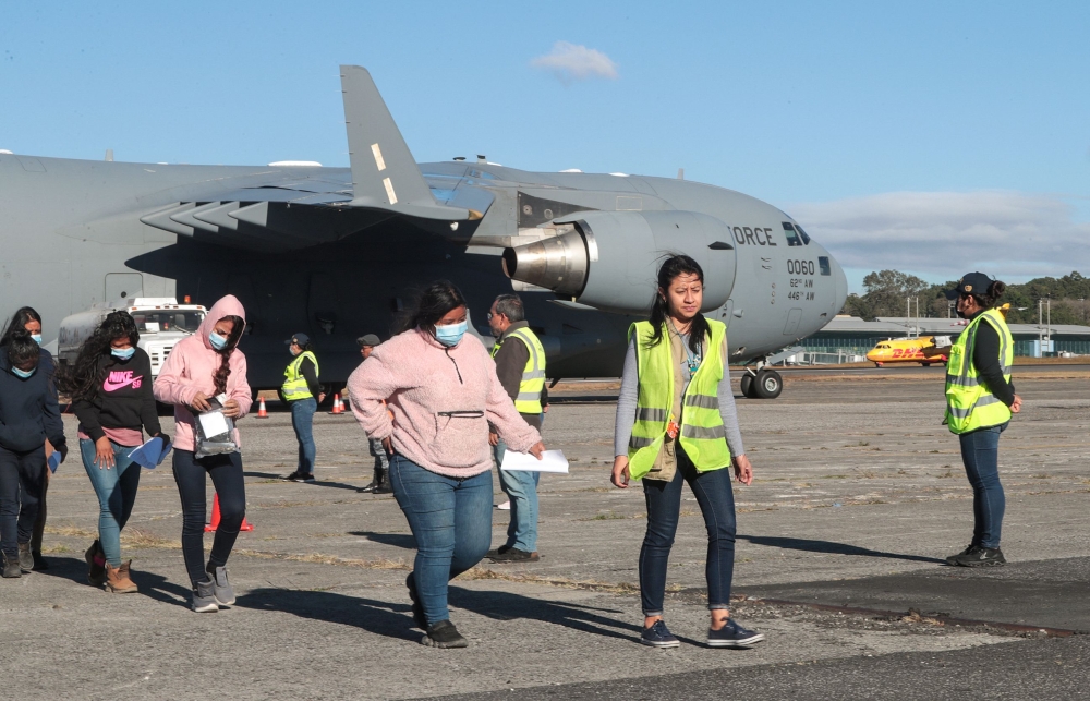 Handout picture released by Guatemalan Migration Institute shows Guatemalan migrants descending from an US military plane after being deported from US at the Guatemalan Air Force Base in Guatemala City yesterday. — AFP pic