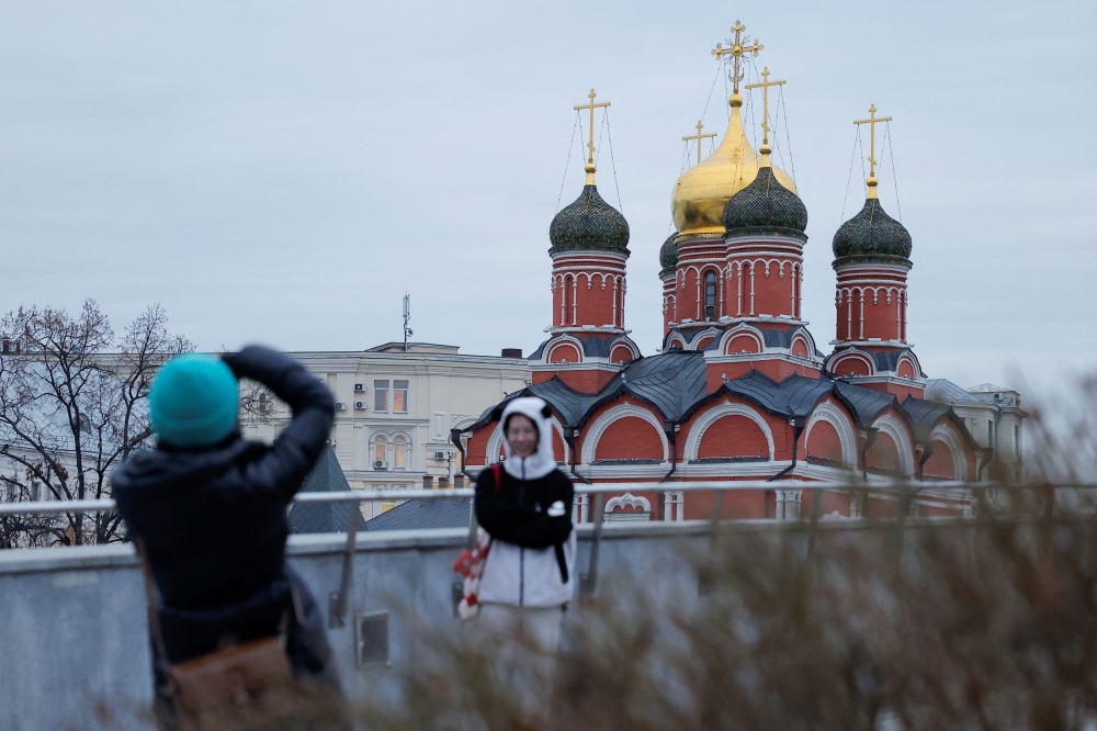 Tourists take pictures in the snowless Zaryadye Park, in Moscow, Russia. — Reuters pic
