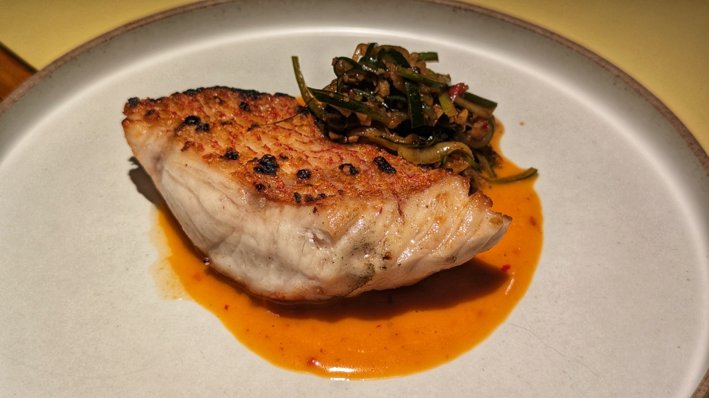 Red Snapper comes with a harissa beurre blanc, and a sliced and grilled cucumber salad. — Picture by Ethan Lau