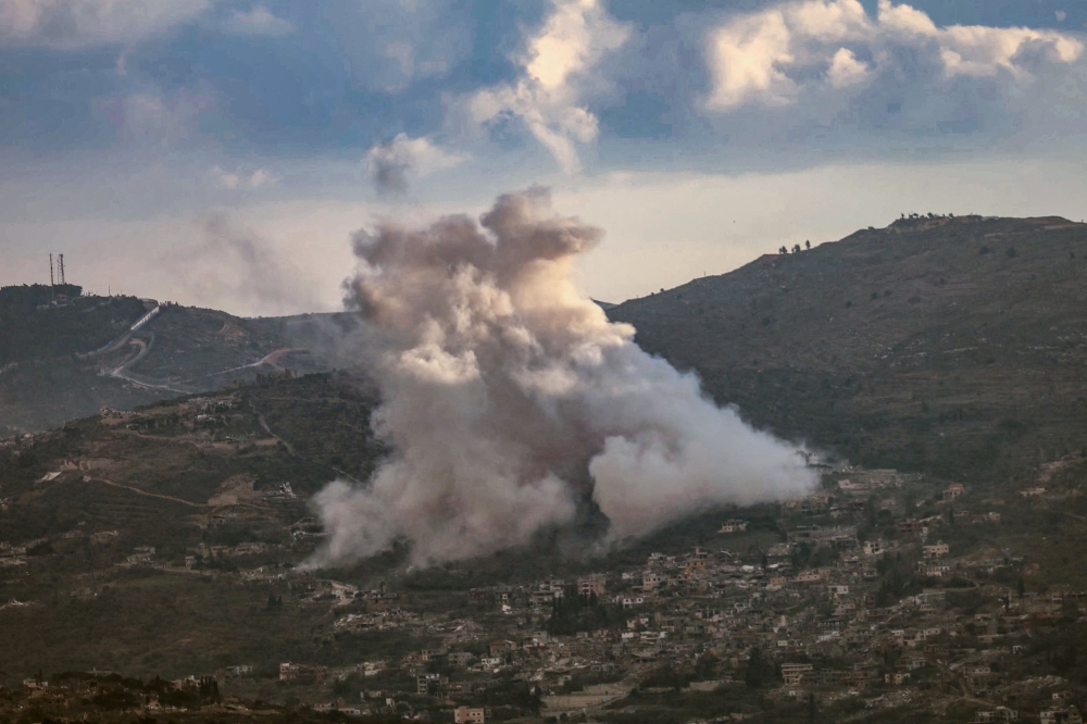 Smoke rises from the site of controlled explosions during demolition activities undertaken by the Israeli army in the southern Lebanese village of Kfarkila. — Pic by AFP