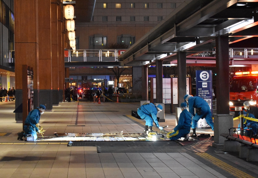 Investigators inspect the scene outside the JR Nagano train station after a man stabbed three people at a bus stop in the city on Wednesday before fleeing the scene, leaving one person dead. — Pic by AFP